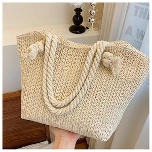 Detail of hand-woven straw tote bag with textured V-shape pattern and soft cotton rope handle