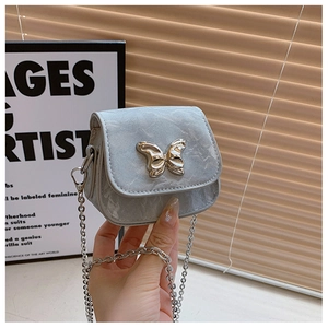 Gros plan du mini sac argenté avec fermoir papillon en métal et détails de cuir texturé