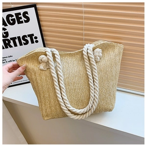Close-up of beige straw tote bag featuring zigzag weave pattern and cotton rope handles