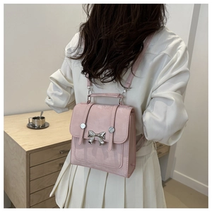 Gros plan du mini sac à dos rose avec noeud papillon porté par un mannequin