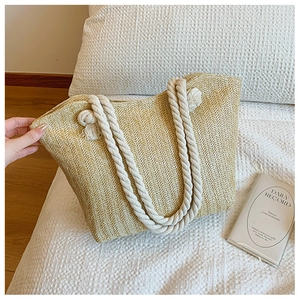 Detail of herringbone straw weave pattern and sturdy beige cotton rope handles on a tote