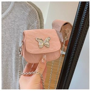 Détail d'un mini sac rose à chaîne avec boucle papillon métallique et texture plissée
