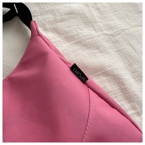 Detail of pink waterproof nylon bag showing the adjustable black strap and Sport tag