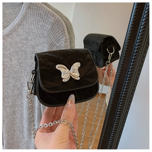 Détail du mini sac bandoulière noir avec breloque papillon argentée et bandoulière chaîne