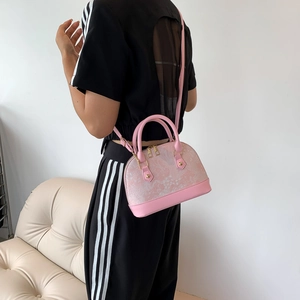 Pink shell crossbody bag with marble texture and gold hardware on female model