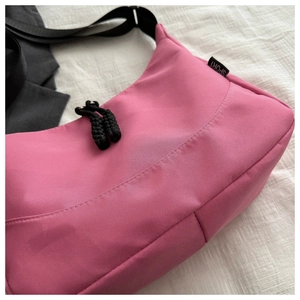 Close-up of rose pink nylon tote bag with black sport tag and woven rope zipper puller