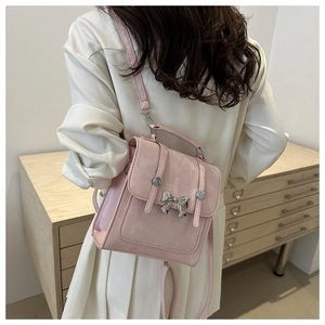 Sac à dos en daim rose avec nœud argenté porté par un mannequin dans un décor doux