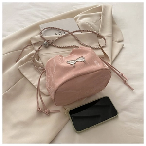 Détail d'un sac seau rose marbré avec nœud argenté et bandoulière en chaîne réglable