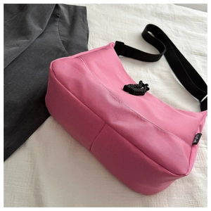 Detailed shot of pink waterproof nylon tote bag with adjustable black shoulder strap