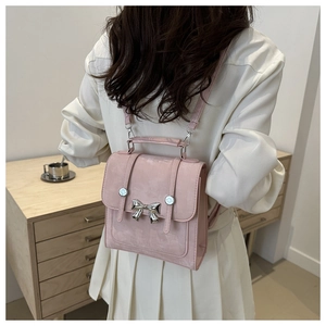 Vue détaillée du sac à dos rose givré avec nœud en métal argenté et fermeture à rabat