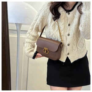Détail du sac vintage en cuir marron avec bandoulière chaîne dorée et fermoir