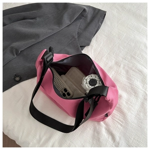 Top view of pink nylon crescent bag showing interior space with phone and umbrella