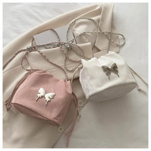 Détails de l'accessoire papillon en métal et texture plissée sur les sacs seaux