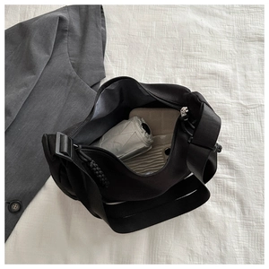 Top view of large nylon shoulder bag interior holding a phone, umbrella and wallet