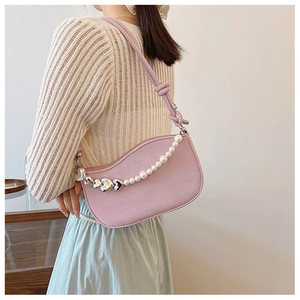 Detail of pink faux leather underarm bag with pearl and silver heart charm chain