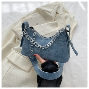 Detail of blue denim crescent bag featuring a chunky silver chain and Y2K vintage texture