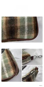 Detail of plaid wool underarm bag with brown leather trim and silver metal chain