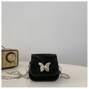 Détail du mini sac noir texturé avec fermoir papillon argenté et bandoulière chaîne