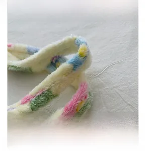 Detail view of the colorful plush handles on a fuzzy multi-color patchwork tote bag