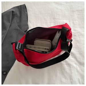 Internal view of a red nylon tote bag with organized items and adjustable black strap