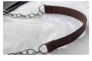 Close-up of brown leather shoulder strap with silver metal chain link for handbag