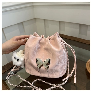 Sac seau rose avec logo papillon argenté et accessoire pompon blanc de haute qualité