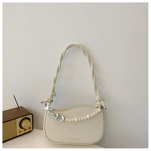 Detail of cream underarm bag with decorative pearls, silver hearts and woven strap