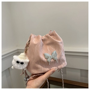 Détail du sac seau rose marbré avec papillon en métal argenté et pompon en peluche