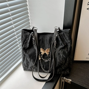 Black crinkled leather tote bag featuring a silver butterfly charm and chain detail