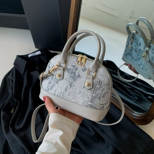 Light gray shell-shaped crossbody bag with elegant white floral embroidery and gold hardware
