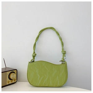 Detail of avocado green pleated underarm bag featuring wave edge and twisted rope strap