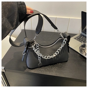 Detail of matte black crescent bag with wide leather strap and chunky silver chain