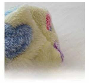 Macro shot of plush tote bag fabric with colorful blue and pink embroidered hearts