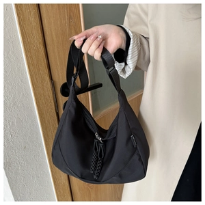 Detail of black nylon crescent bag with double braided rope zipper and sport tag