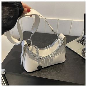 Detail of white crescent shoulder bag featuring chunky silver chains and a wide strap