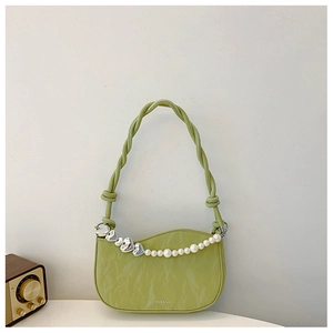 Close-up of light green pleated leather shoulder bag with pearl chain and heart metal clasp