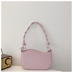 Detail of pink shoulder bag with wavy top edge and twisted rope handle texture