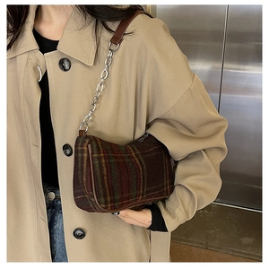 Close-up of vintage plaid underarm bag with tweed fabric and metal chain shoulder strap