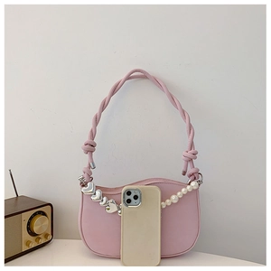 Detailed view of pink crescent bag with woven handle and elegant pearl chain decor