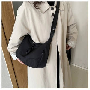 Adjustable shoulder strap detail on a black crescent nylon crossbody sport bag