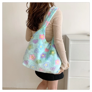 Detail of soft plush tote bag with colorful floral patterns on a light green base