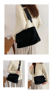 Détail d'un sac à bandoulière noir en daim avec large sangle en toile et rabat chic