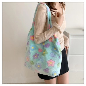 Detail of soft fuzzy tote bag featuring colorful flower and heart patterns on light blue faux fur