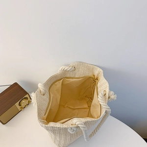 Beige woven straw tote bag with white rope handles and zipper closure, top view design