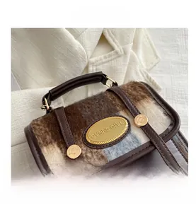 Detail shot of vintage wool bucket bag with brown leather straps and gold metal hardware