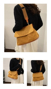 Détail du sac bandoulière en daim jaune moutarde avec large bandoulière et rabat assorti