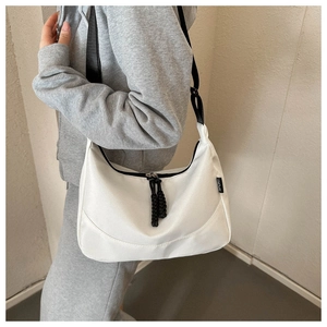 Detail of white nylon crescent bag showing the black SPORT label and woven zipper puller
