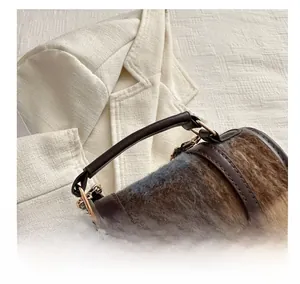 Detail view of winter woolen bucket bag with brown faux fur and gold metal plaque