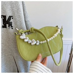 Detail of pea green shoulder bag with wrinkled texture and pearl heart chain strap