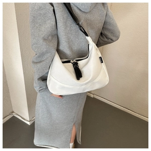 Detailed view of white crescent canvas bag featuring a sport label and adjustable strap